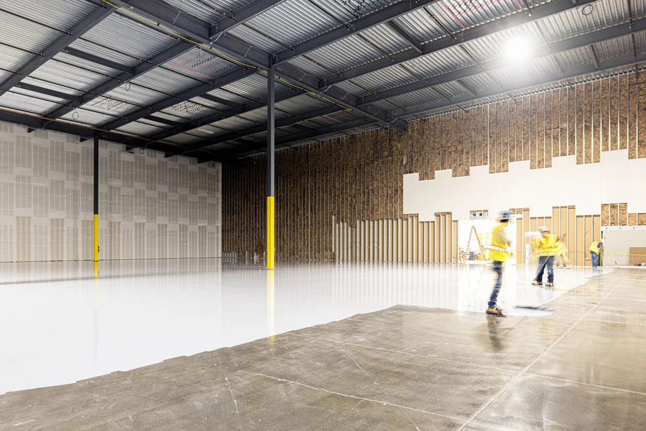 Floor coating being spread across a prepared industrial floor