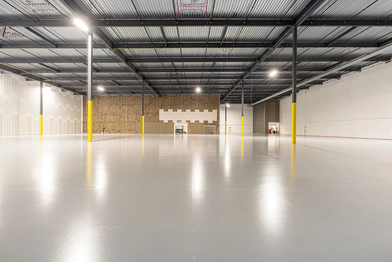 Smooth grey floor coating across a large industrial interior